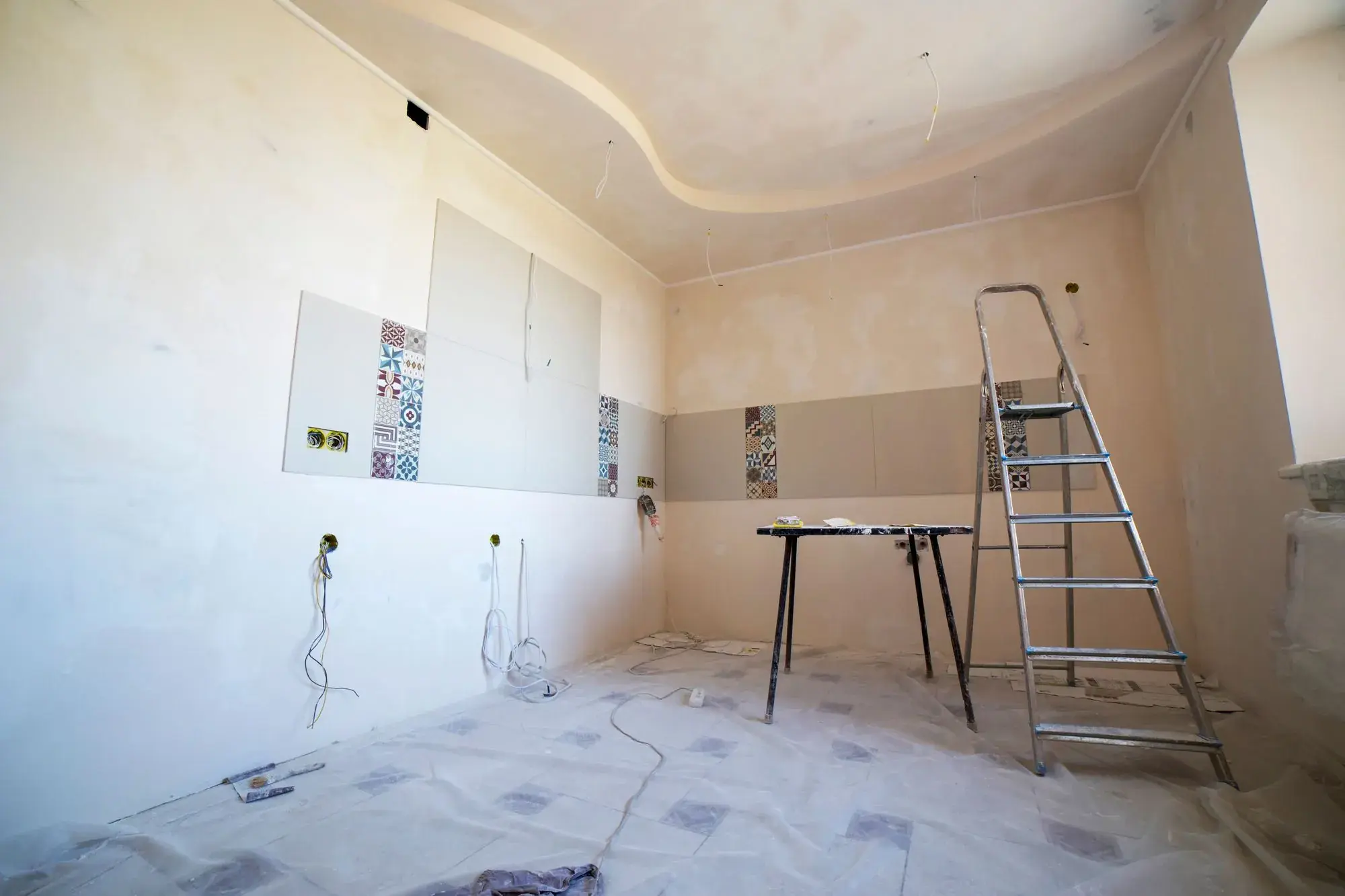 Room being renovated with a ladder and a protected floor