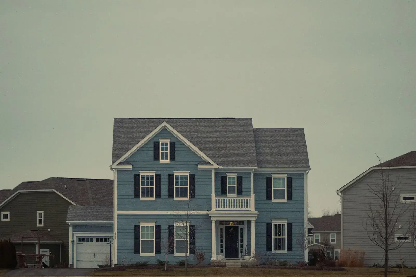 Blue colonial-style house in a suburban neighborhood